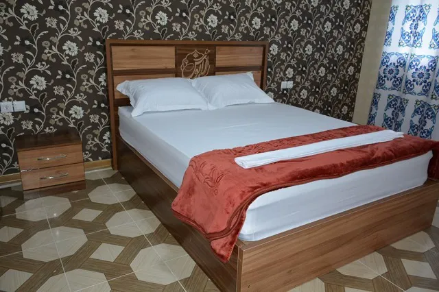 تخت دونفره چوبی در اتاق هتل لابوس