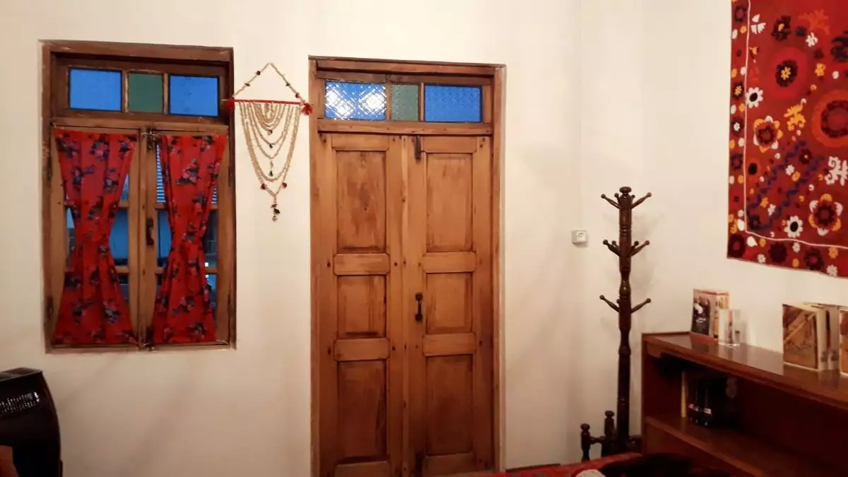 اتاق هتل آوش با در چوبی و پنجره پرده‌دار