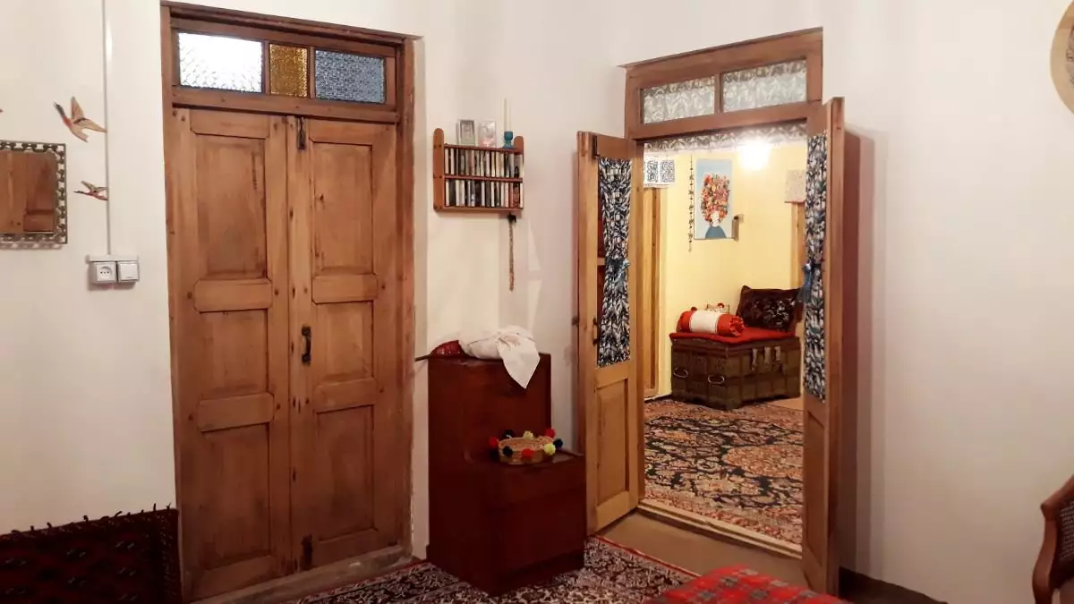 ورودی خانه آوش با درهای چوبی و اتاق پذیرایی