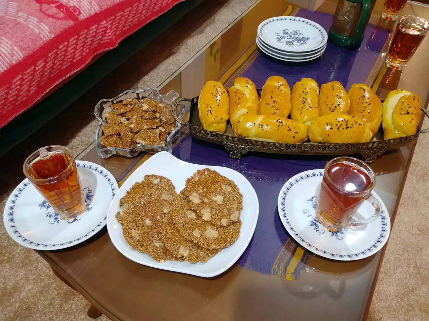 نان و شیرینی محلی کنار استکان‌های چای در هتل آوش