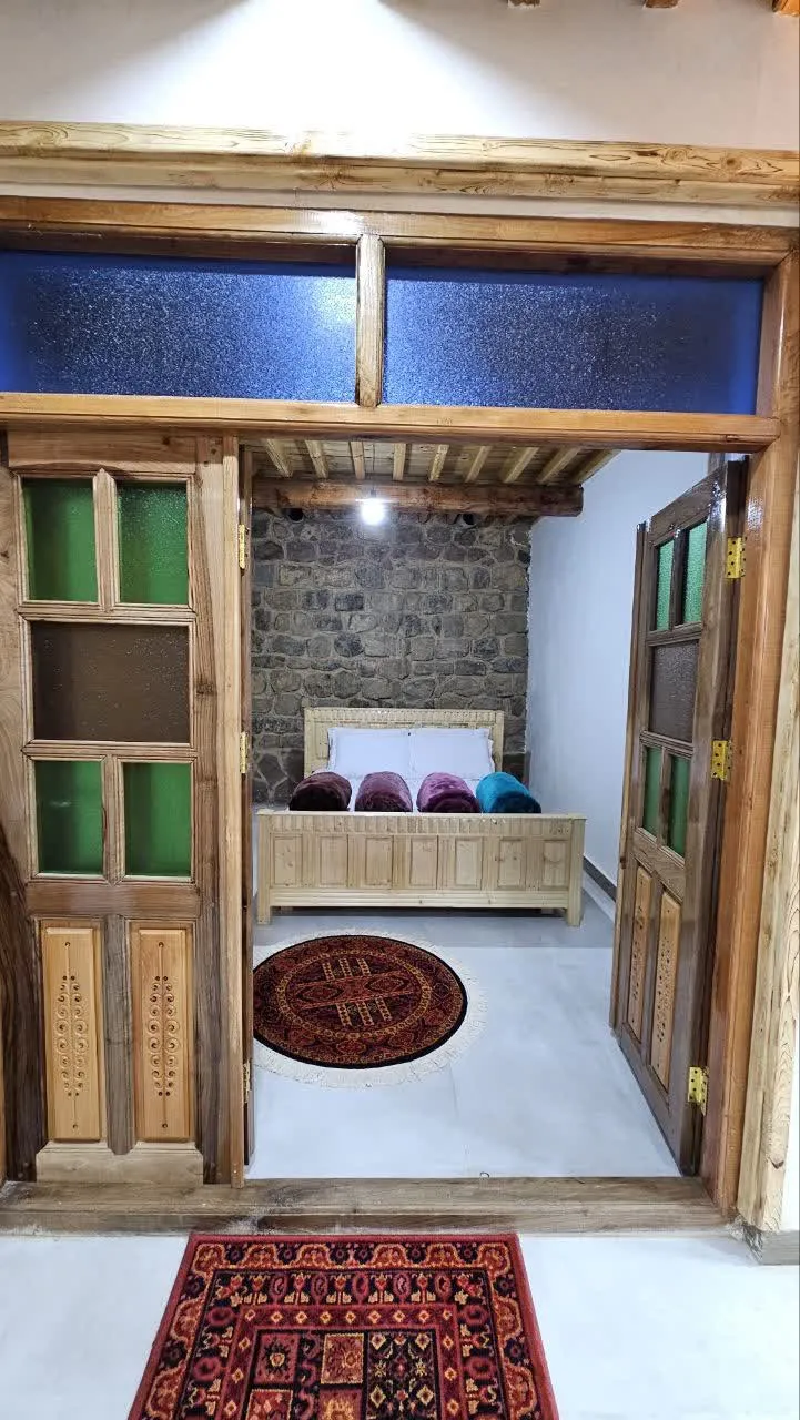 ماسوله؛ اتاق خواب چوبی با تخت و قالیچه