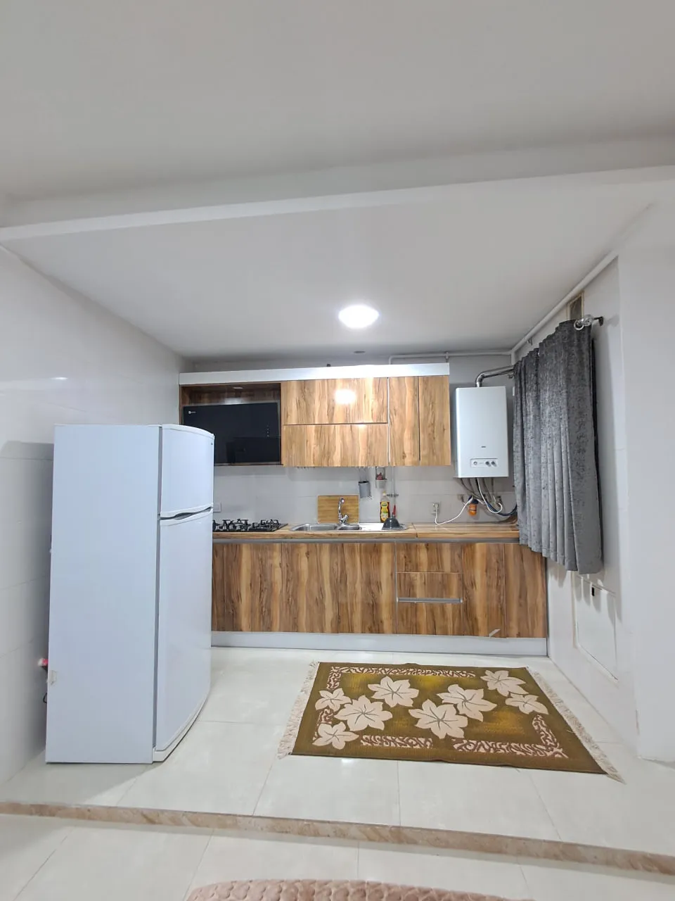 آشپزخانه برجیس با کابینت چوبی و یخچال