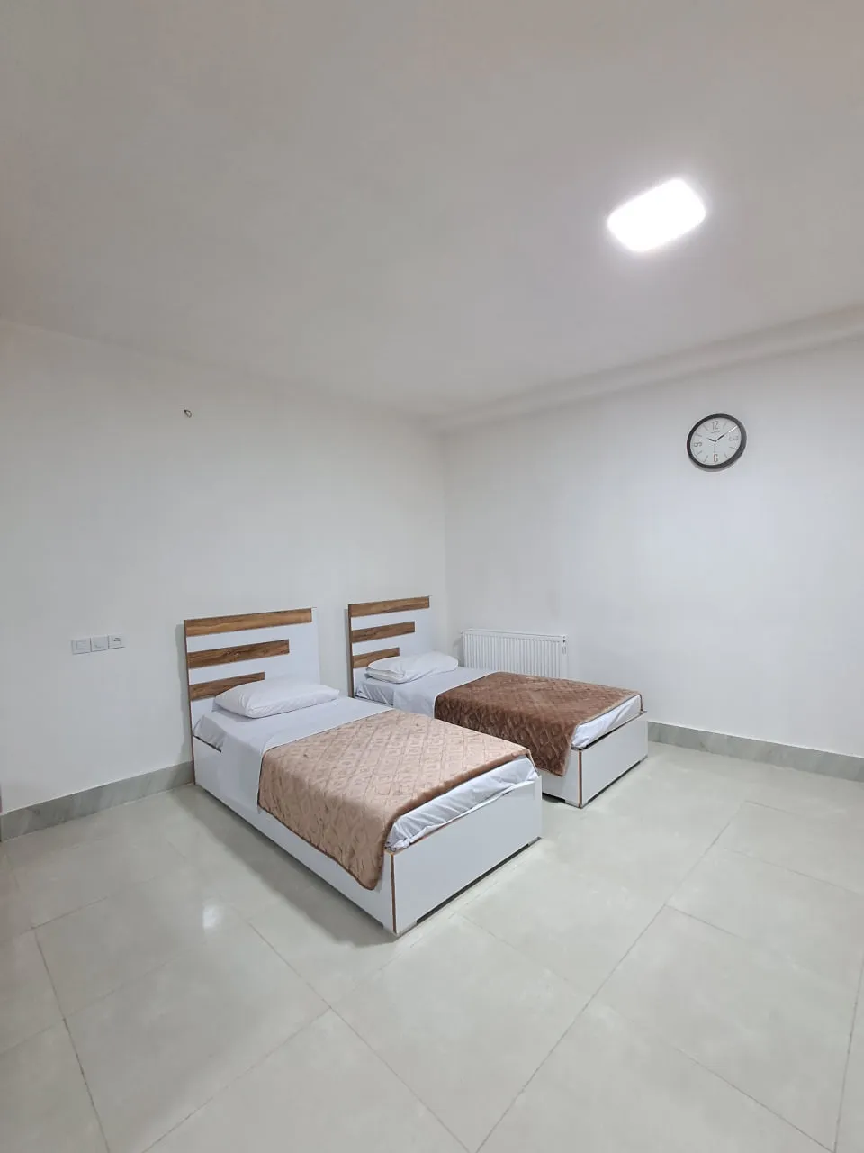 اتاق برجیس با دو تخت یکنفره و ساعت دیواری