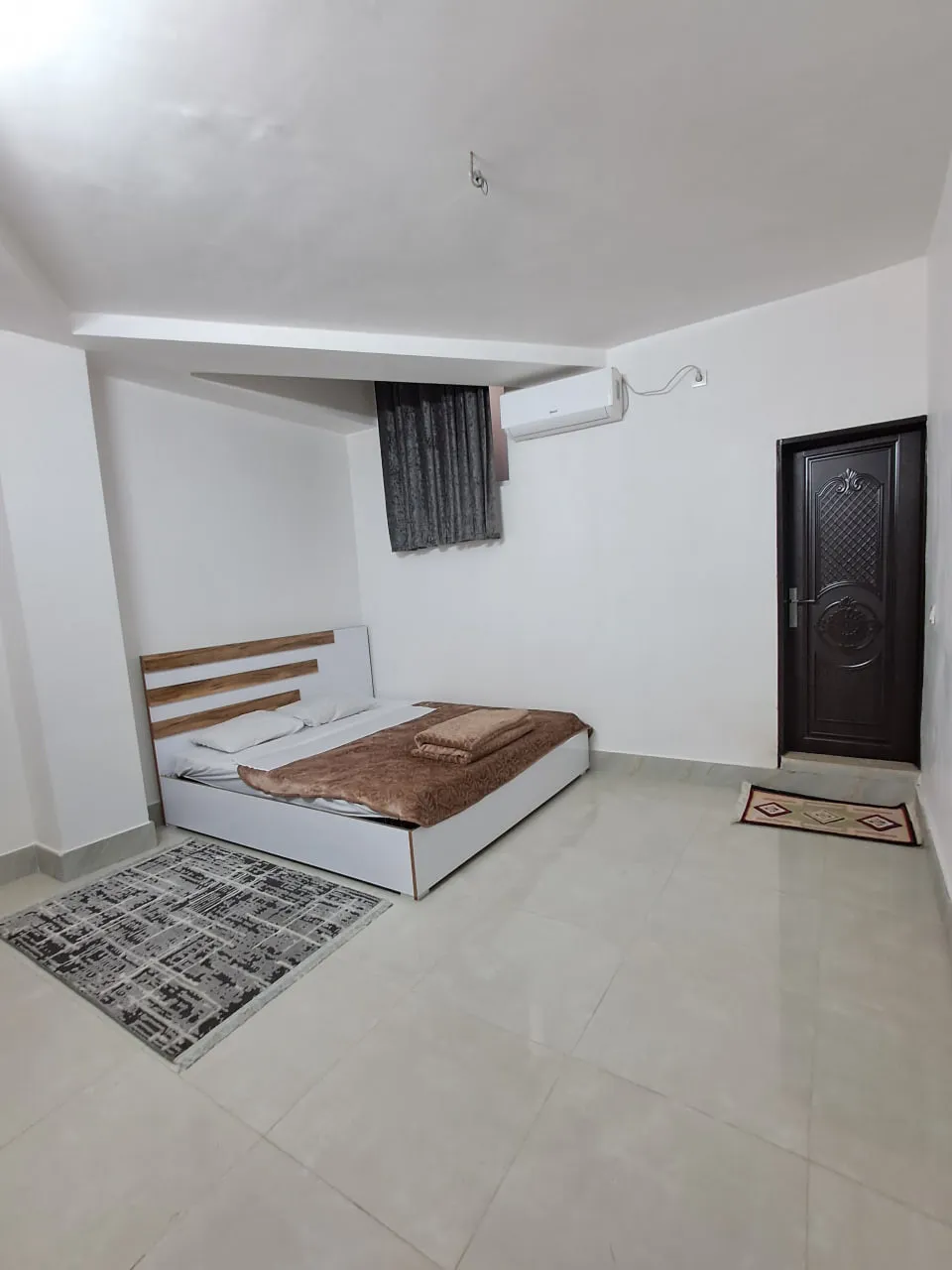 اتاق برجیس با تخت دونفره و درِ چوبی تیره