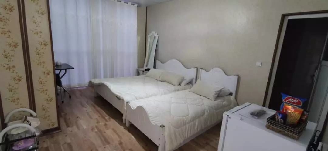 دو تخت یک‌نفره در اتاق کندلوس