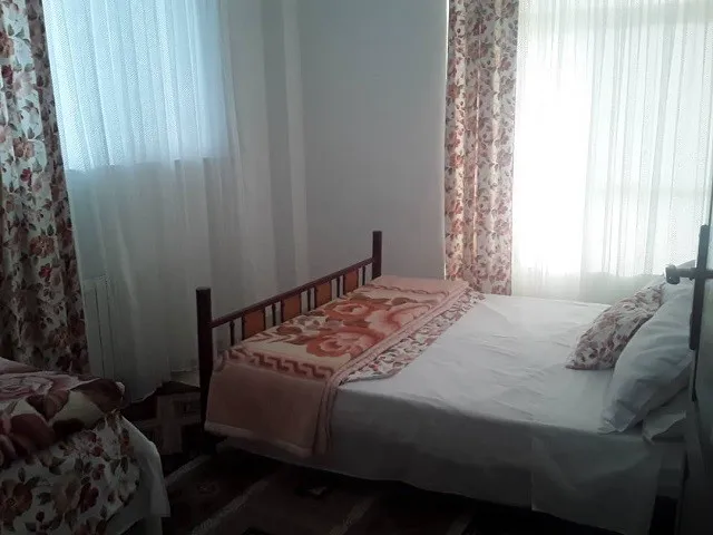 تخت دونفره با روتختی گل‌دار در هتل رادمهر
