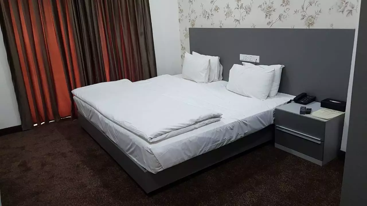 تخت دونفره و میز کنار تخت در هتل المقام