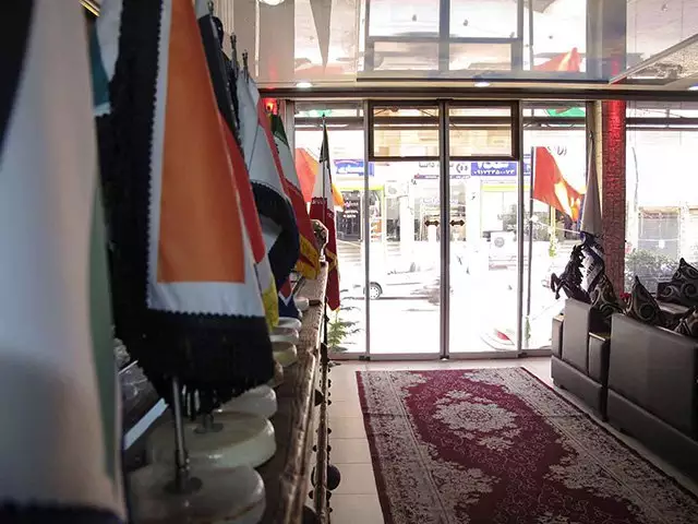 ورودی شیشه‌ای هتل آسمان با ردیف پرچم‌ها