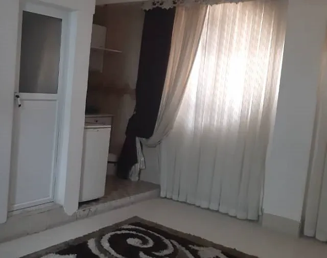 آشپزخانه کوچک و پنجره پرده‌دار در هتل کویر